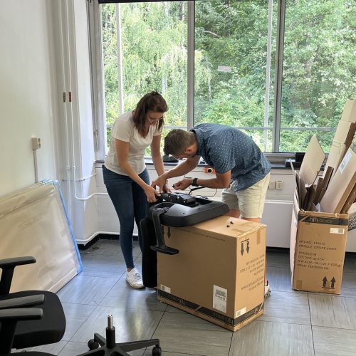 Laura Albring und Dominic Laaf bauen Möbel im neuen Büro am Forschungszentrum Jülich auf